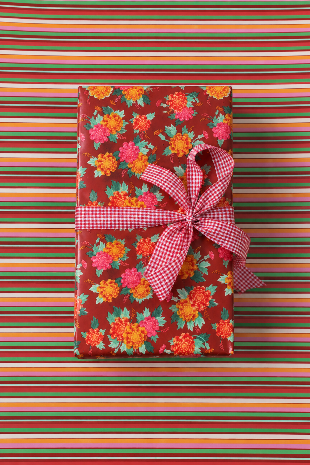 Rollo de papel de regalo Amalfi: regalo envuelto con la cara A (flores) y cinta rosada sobre papel de la cara B (franjas)